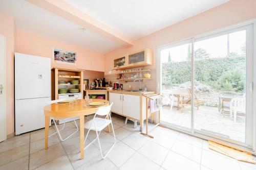 eine Küche mit einem Tisch und einem großen Fenster in der Unterkunft Maison Besun in Dieulefit