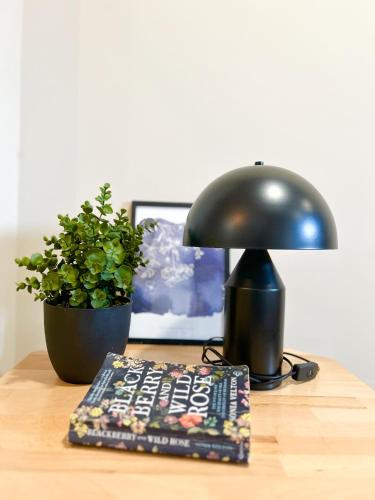 a lamp sitting on a table next to a plant at Urban Residence Apartments in Mostar
