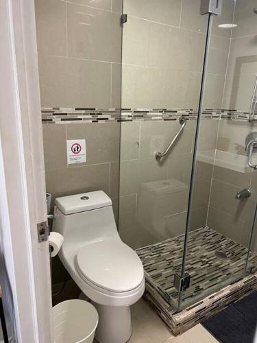a bathroom with a toilet and a glass shower at Cozy and sweet home in Miami