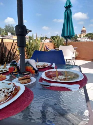 a glass table with plates of food on it at Posada Maria Luisa in San Miguel de Allende