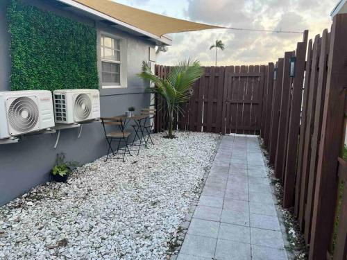 een achtertuin met een hek en een tafel en stoelen bij Cozy and sweet home in Miami