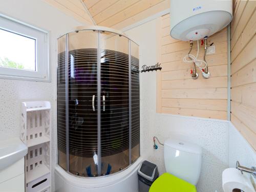 a small bathroom with a shower in a tiny house at Domki Malibu in Rusinowo