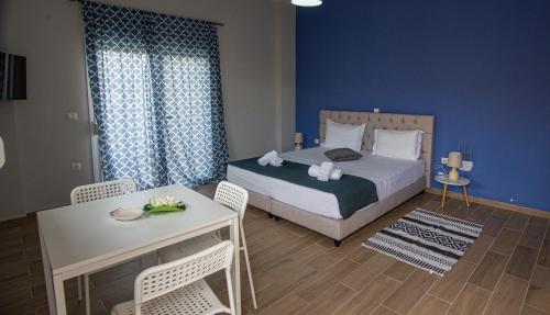 um quarto com uma cama, uma mesa e cadeiras em Nikitas Apartments & Suites em Kanali