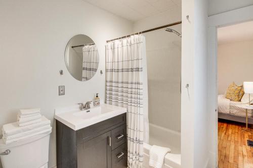 een witte badkamer met een wastafel en een douche bij Bright Lawrence Vacation Rental about 1 Mi to KU! in Lawrence