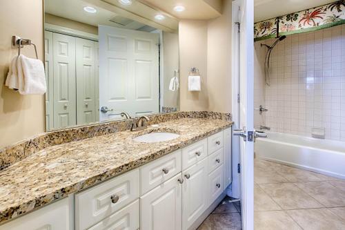 a bathroom with a sink and a mirror and a tub at Westwinds 4826 in Destin