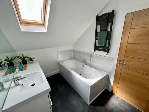 a white bathroom with a tub and a sink at Lovely house & garden, short walk to town & beach. in Fife