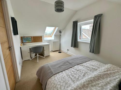 a bedroom with a bed and a desk and a window at Lovely house & garden, short walk to town & beach. in Fife