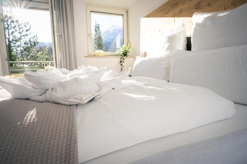 Cama blanca con sábanas blancas y ventana en Pott-Alm, en Bad Reichenhall