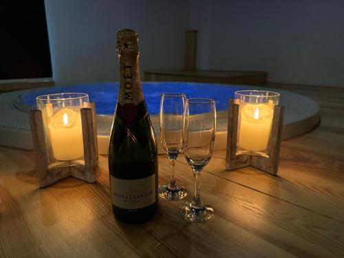 a bottle of wine and two glasses on a table with candles at Hotel & wellness Hejtmanka in Mladá Boleslav