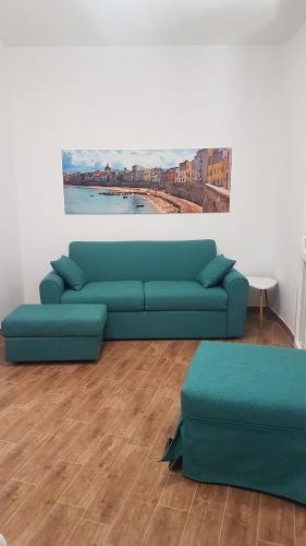 a blue couch in a living room with a painting at TRAPANI CITY SEA APARTMENT in Trapani