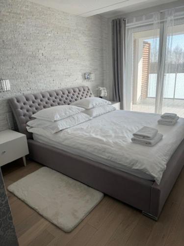 a large bed in a bedroom with a window at AKOYA APARTMENTS Bianco in Koszalin