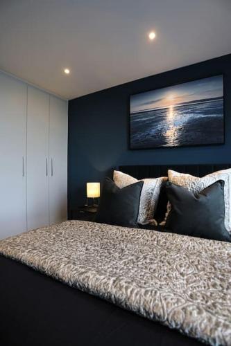 a bedroom with a bed with a picture on the wall at SoHot Stays Beach Haven Apt With Sea Views A Balcony & Free Parking in Ramsgate