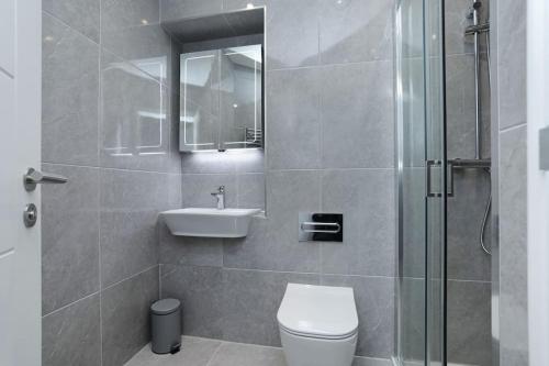 a bathroom with a toilet and a sink and a shower at SoHot Stays Beach Haven Apt With Sea Views A Balcony & Free Parking in Ramsgate