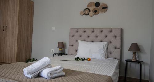 a bedroom with a bed with two towels on it at Nikitas Apartments & Suites in Kanali