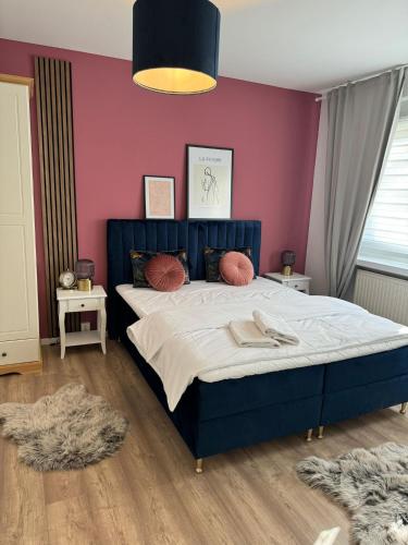1 dormitorio con 1 cama grande y pared morada en Appartement No 13, en Sondershausen