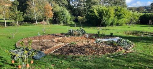 a garden with plants in the middle of a field at Domaine de la cure in Curgy