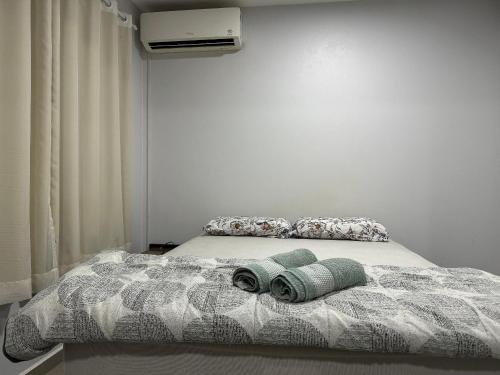 a bedroom with a bed with two towels on it at Apartamento em vila Industrial Bloco 03 Ap 202 in Toledo