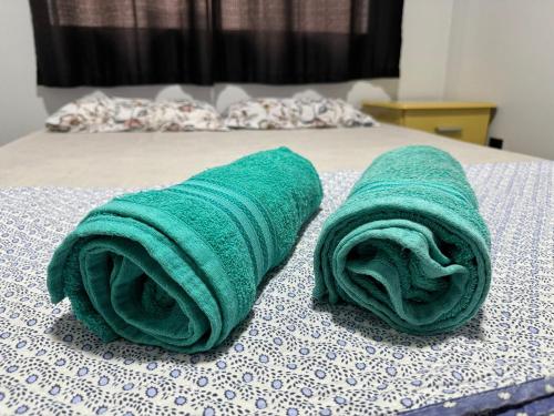 two green towels sitting on top of a bed at Apartamento em vila Industrial Bloco 03 Ap 202 in Toledo