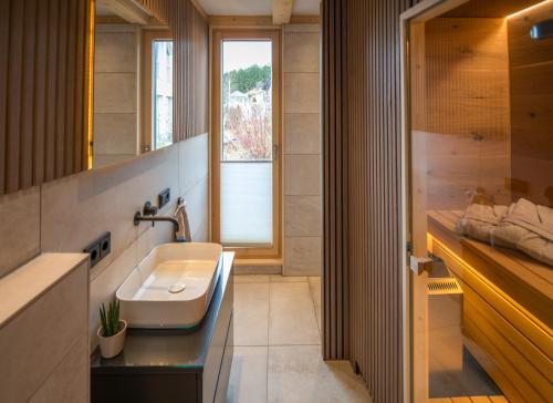 uma casa de banho com um lavatório e uma janela em Chalet Herz³ em Hohenau