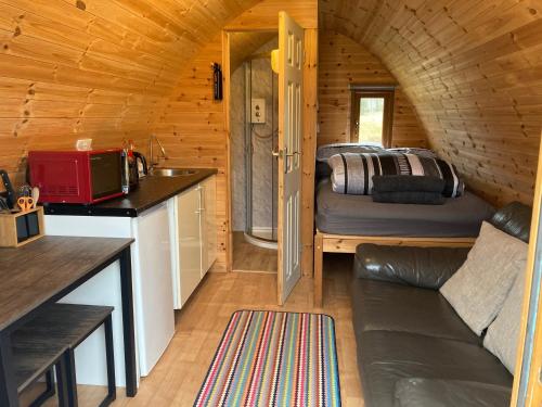 a tiny house with a kitchen and a bed at kilcamb camping Pods in Edinbane
