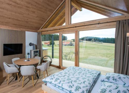 a room with a bed and a table and a window at Chalet Herz³ in Hohenau