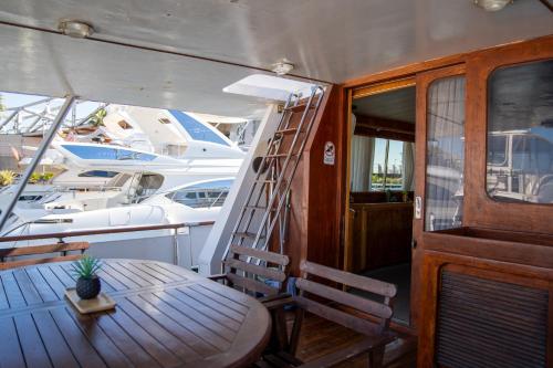 a wooden table and chair on a boat with a ladder at Boat ALOHA in Barcelona