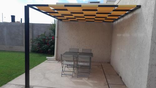 a patio with a table and chairs under a canopy at Casa Los Teritos, Ruta del Vino in Maipú