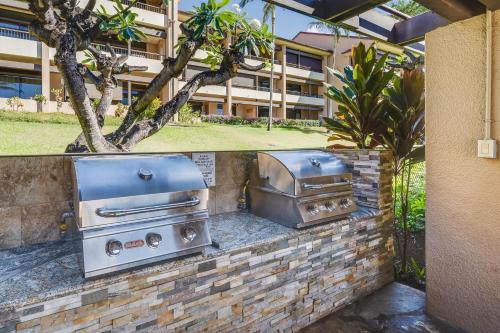 two barbecue equipment on a brick wall in front of a building at Kaanapali Royal H101 · KRL H101 Remodel 2BD Condo Pool Kaanapali in Kaanapali