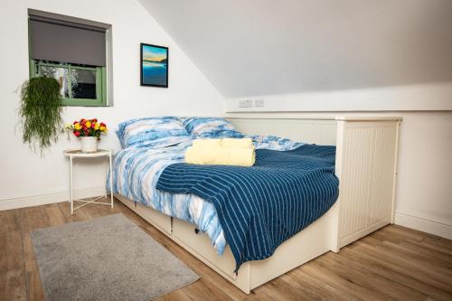 ein Schlafzimmer mit einem Bett mit einer blauen Decke in der Unterkunft Cwtch Lackerlee in Haverfordwest