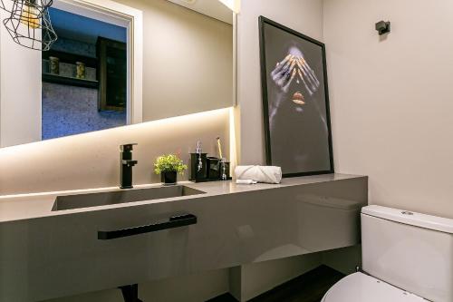 a bathroom with a sink and a mirror at Apto moderno prédio novo em Jurerê JPR212 in Florianópolis