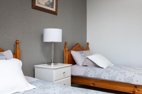 a bedroom with two beds and a lamp on a night stand at Shannonside - Stylish 5 Bed Marina home & 40ft mooring in Termonbarry