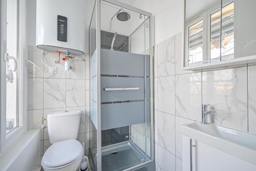 une salle de bain blanche avec des toilettes et un lavabo dans l'établissement Appartement cosy, neuf et tout equipé, à 3mn à pied de Paris, à Clichy