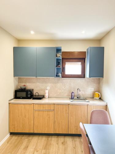 a kitchen with wooden cabinets and a sink at Urban Residence Apartments in Mostar