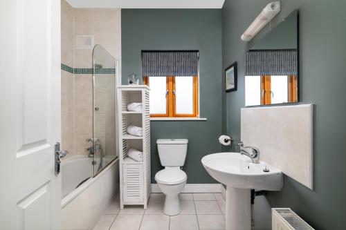 a bathroom with a white toilet and a sink at Shannonside - Stylish 5 Bed Marina home & 40ft mooring in Termonbarry