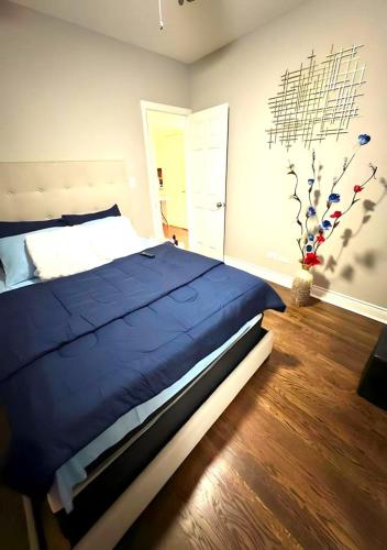 a bedroom with a large bed with a blue comforter at Fully Equipped Cozy 4/5 BR in Chicago