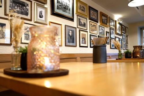 un vase assis au-dessus d'une table avec des photos sur le mur dans l'établissement Zum Simonbräu, à Bitburg