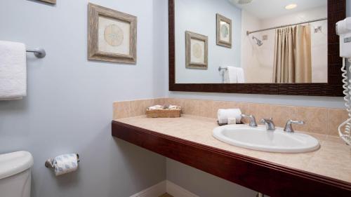 W łazience znajduje się umywalka, toaleta i lustro. w obiekcie Luau II 7021 Studio w mieście Destin