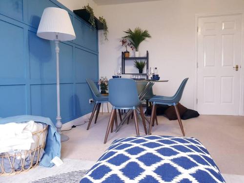 een slaapkamer met blauwe muren en een tafel en stoelen bij Hyde Park - Park Hill - Central - 2 Bedrooms - Free On-Site Parking - Netflix - Fast WiFi in Sheffield