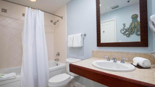 a bathroom with a sink and a toilet and a mirror at Luau II 7023 in Destin