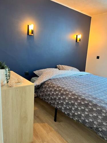 une chambre avec un lit avec un mur bleu dans l'établissement Petite maison avec terrasse, à La Penne-sur-Huveaune