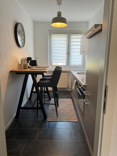 cocina con mesa, 2 sillas y nevera en Appartement No 13, en Sondershausen