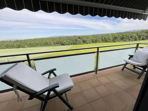 balcón con 2 sillas y vistas al agua en Mirador Rioja alta golf, en Cirueña
