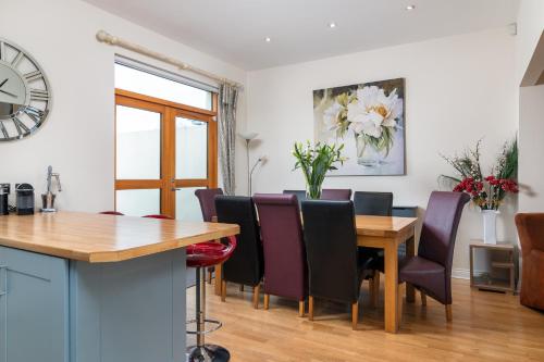 a dining room with a wooden table and chairs at Shannonside - Stylish 5 Bed Marina home & 40ft mooring in Termonbarry