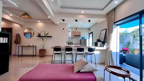salon z purpurowym łóżkiem i kuchnią w obiekcie Welcome to your happy place ! w mieście Dar Bouazza