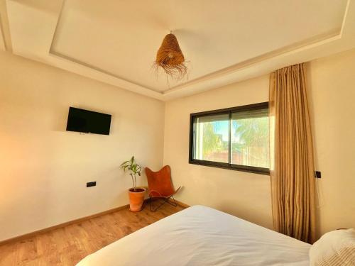 1 dormitorio con 1 cama, 1 silla y 1 ventana en Welcome to your happy place ! en Dar Bouazza