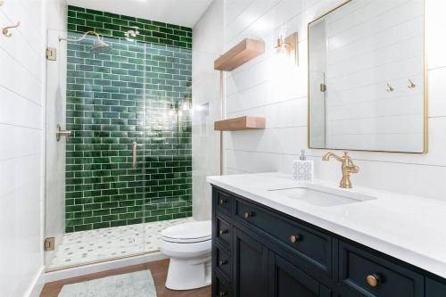 y baño con lavabo y ducha de azulejos verdes. en The Pool House at Fr. Sorin's w/ Paddle Tennis, en South Bend