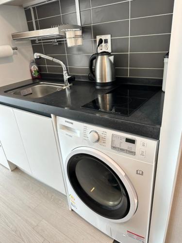 a kitchen with a washing machine and a sink at Trip to Songdo in Incheon