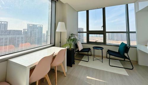 a room with chairs and a table and a large window at Trip to Songdo in Incheon