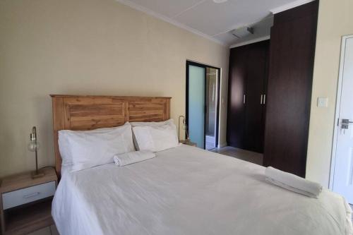 a bedroom with a large bed with white sheets and pillows at Home Away From Home in Midrand