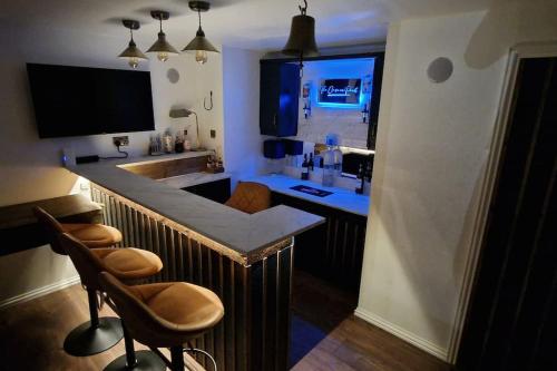 a kitchen with a bar with two chairs and a sink at The Case in Point in Witney
